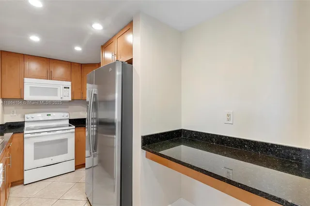 a kitchen with a refrigerator and white cabinets