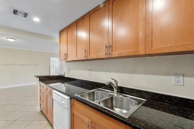 a kitchen with granite countertop a sink and cabinets