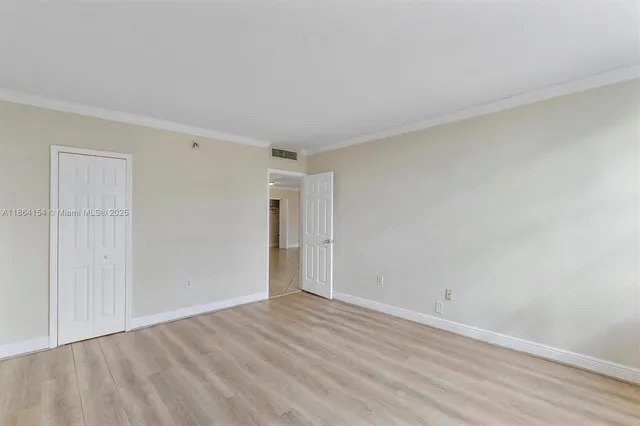 a view of empty room with wooden floor