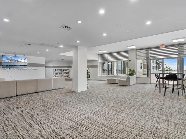 a room with wooden floor pool table and windows