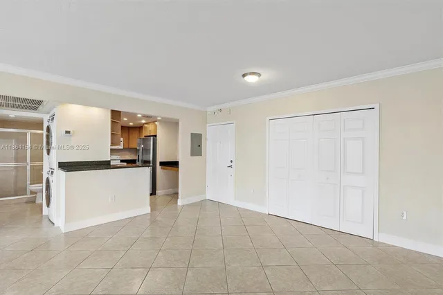 a view of a kitchen with refrigerator and white cabinets