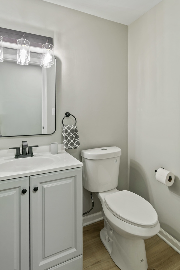 1554 Chickasaw Drive Naperville, IL 60563 - Photo 20 of 32 a bathroom with a toilet a sink and mirror