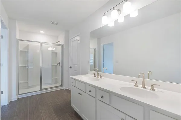 a bathroom with double vanity sink and a mirror