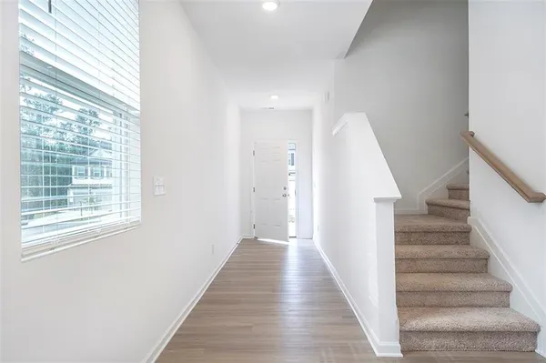 a view of a hallway with wooden floor and windows