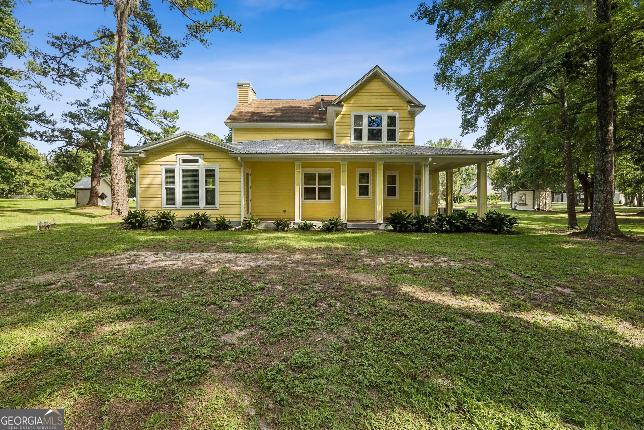 706 Hopewell Point Road White Oak, GA 31568 - Photo 69 of 84 The rear elevation highlights the home's charming architecture, extensive covered porch space, and peaceful setting on a spacious lot.