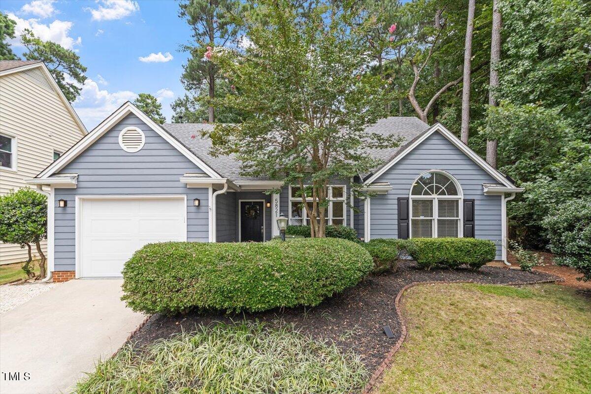 a front view of a house with a yard and trees