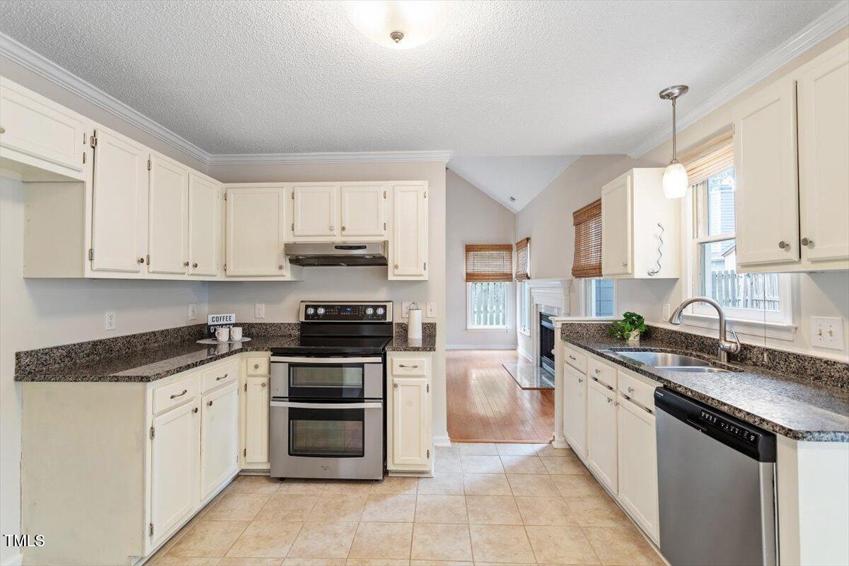 5821 Edgebury Road Raleigh, NC 27613 - Photo 12 of 37 a kitchen with stainless steel appliances granite countertop a stove sink and cabinets