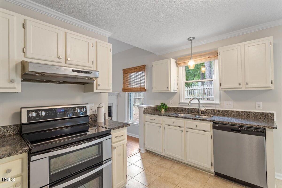 5821 Edgebury Road Raleigh, NC 27613 - Photo 13 of 37 a kitchen with granite countertop a stove sink and cabinets