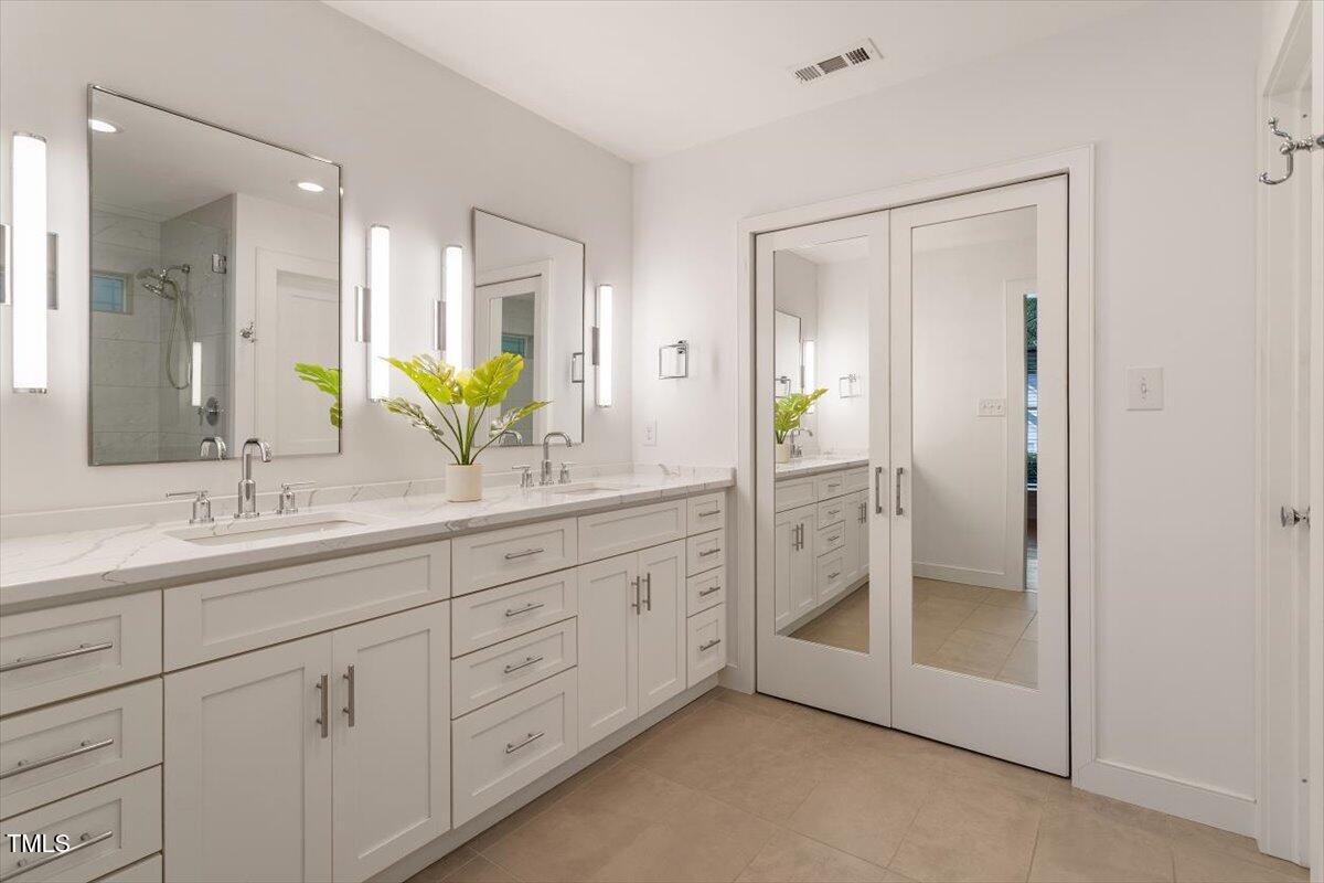 5821 Edgebury Road Raleigh, NC 27613 - Photo 19 of 37 a bathroom with a double vanity sink and a mirror