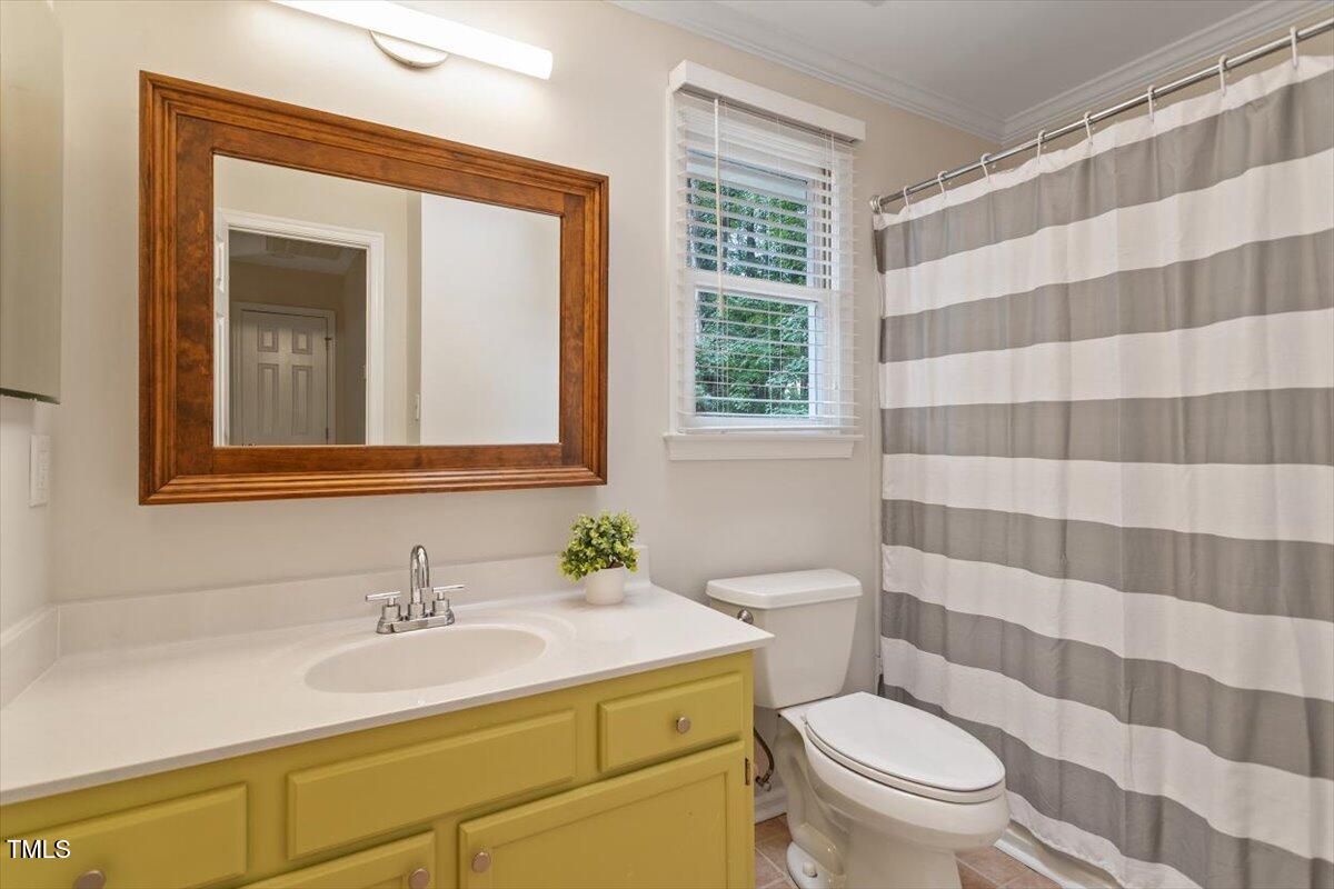 5821 Edgebury Road Raleigh, NC 27613 - Photo 24 of 37 a bathroom with a sink toilet a mirror and shower