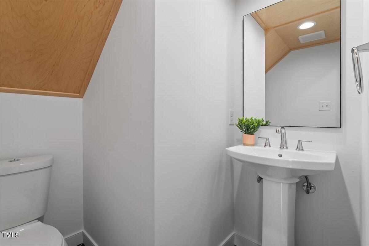 5821 Edgebury Road Raleigh, NC 27613 - Photo 25 of 37 a bathroom with a toilet sink and mirror