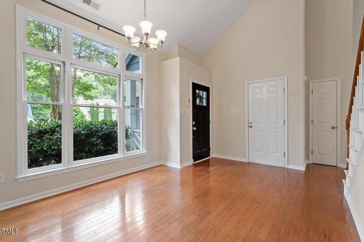 5821 Edgebury Road Raleigh, NC 27613 - Photo 4 of 37 a view of an empty room with wooden floor and a window