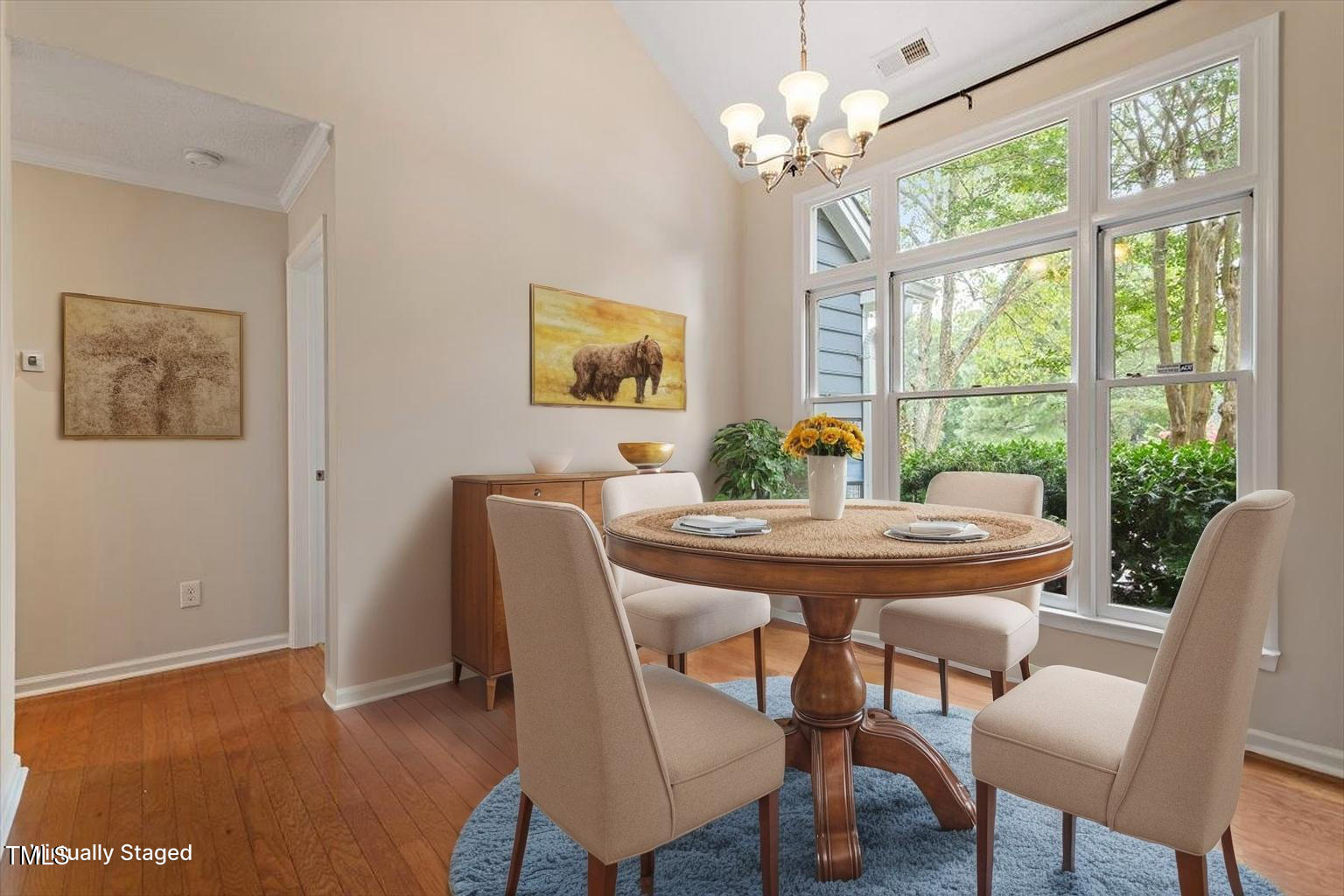 5821 Edgebury Road Raleigh, NC 27613 - Photo 6 of 37 a dining room with furniture a large window and wooden floor