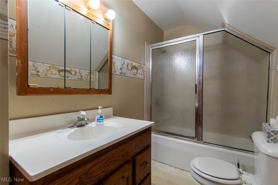 3555 Marks Road Medina, OH 44256 - Photo 12 of 19 Full bathroom featuring vanity, lofted ceiling, bath / shower combo with glass door, and toilet
