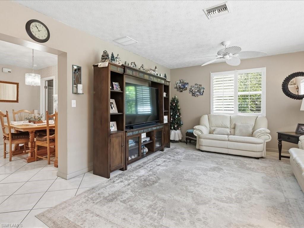 3890 27th Avenue Southwest Naples, FL 34117 - Photo 11 of 38 a living room with furniture a flat screen tv and a window