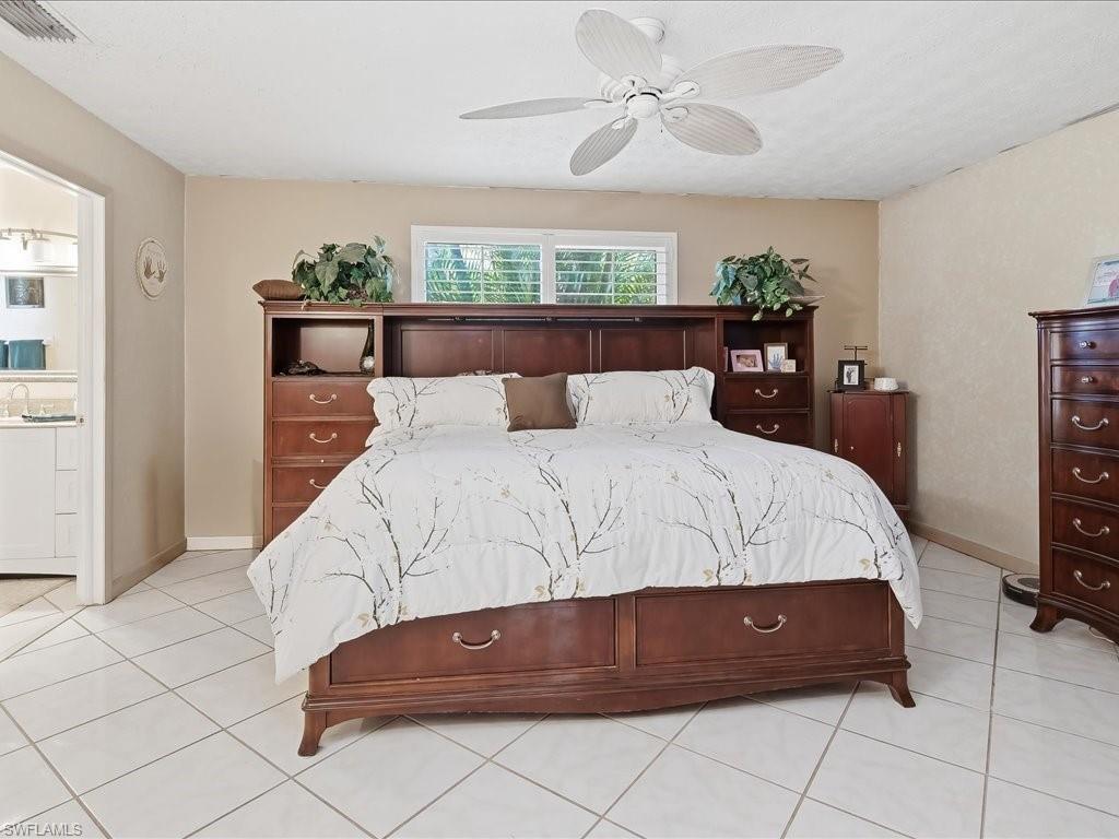 3890 27th Avenue Southwest Naples, FL 34117 - Photo 14 of 38 a bedroom with a large bed and a chandelier