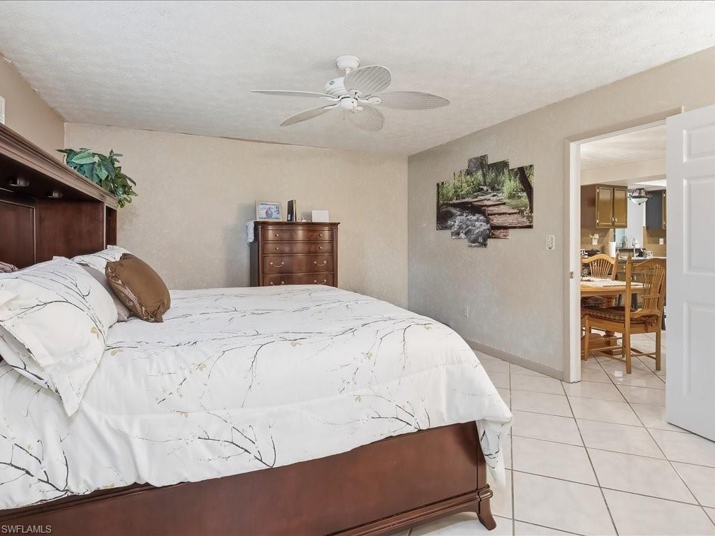 3890 27th Avenue Southwest Naples, FL 34117 - Photo 15 of 38 a bedroom with a bed and a cabinets