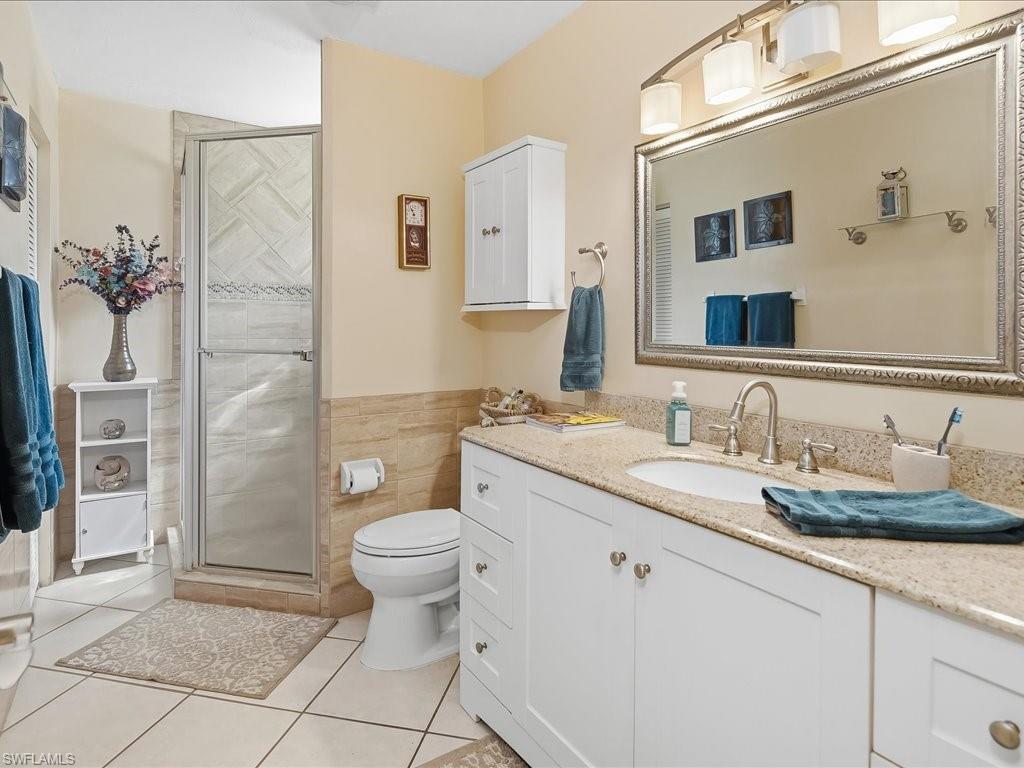 3890 27th Avenue Southwest Naples, FL 34117 - Photo 16 of 38 a bathroom with a granite countertop sink a toilet and a mirror
