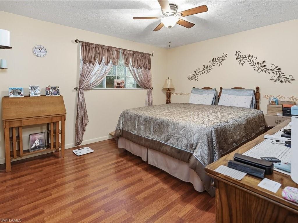 3890 27th Avenue Southwest Naples, FL 34117 - Photo 17 of 38 a bedroom with a bed and a fireplace