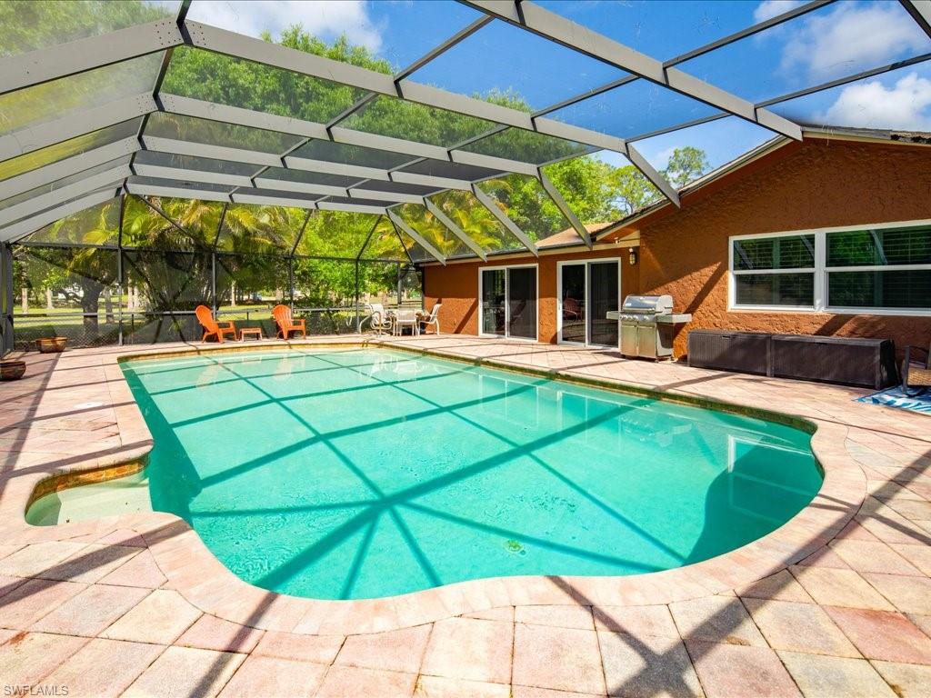3890 27th Avenue Southwest Naples, FL 34117 - Photo 22 of 38 a view of a backyard with table and chairs under an umbrella