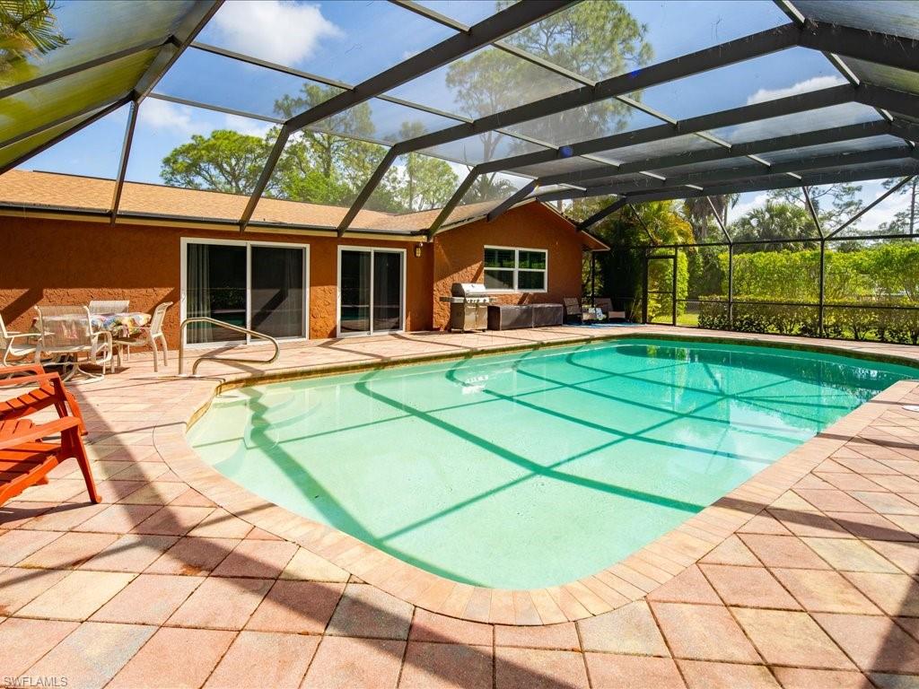 3890 27th Avenue Southwest Naples, FL 34117 - Photo 23 of 38 a view of a patio with a table and chairs under an umbrella