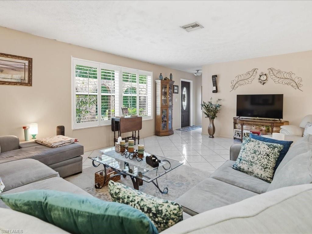 3890 27th Avenue Southwest Naples, FL 34117 - Photo 7 of 38 a living room with furniture and a flat screen tv