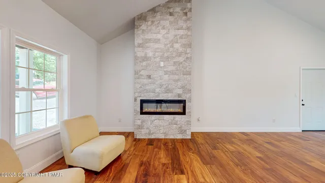 a living room with fireplace furniture and hard wood floor