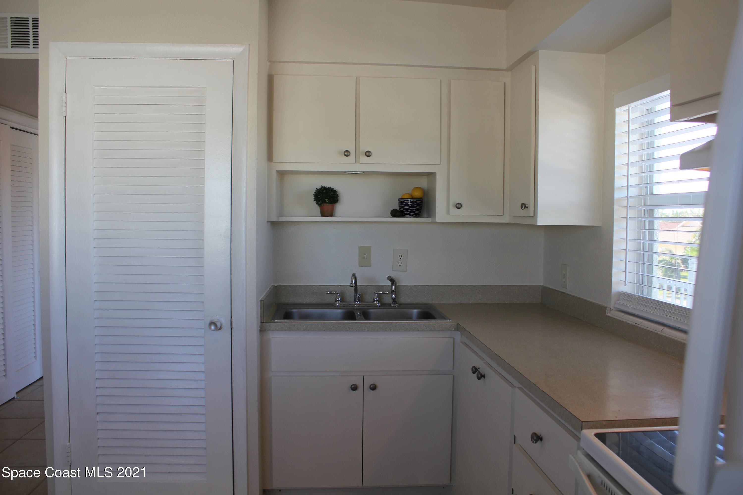 651 Palm Drive, Unit E3 Satellite Beach, FL 32937 - Photo 12 of 25 a kitchen with a sink and cabinets