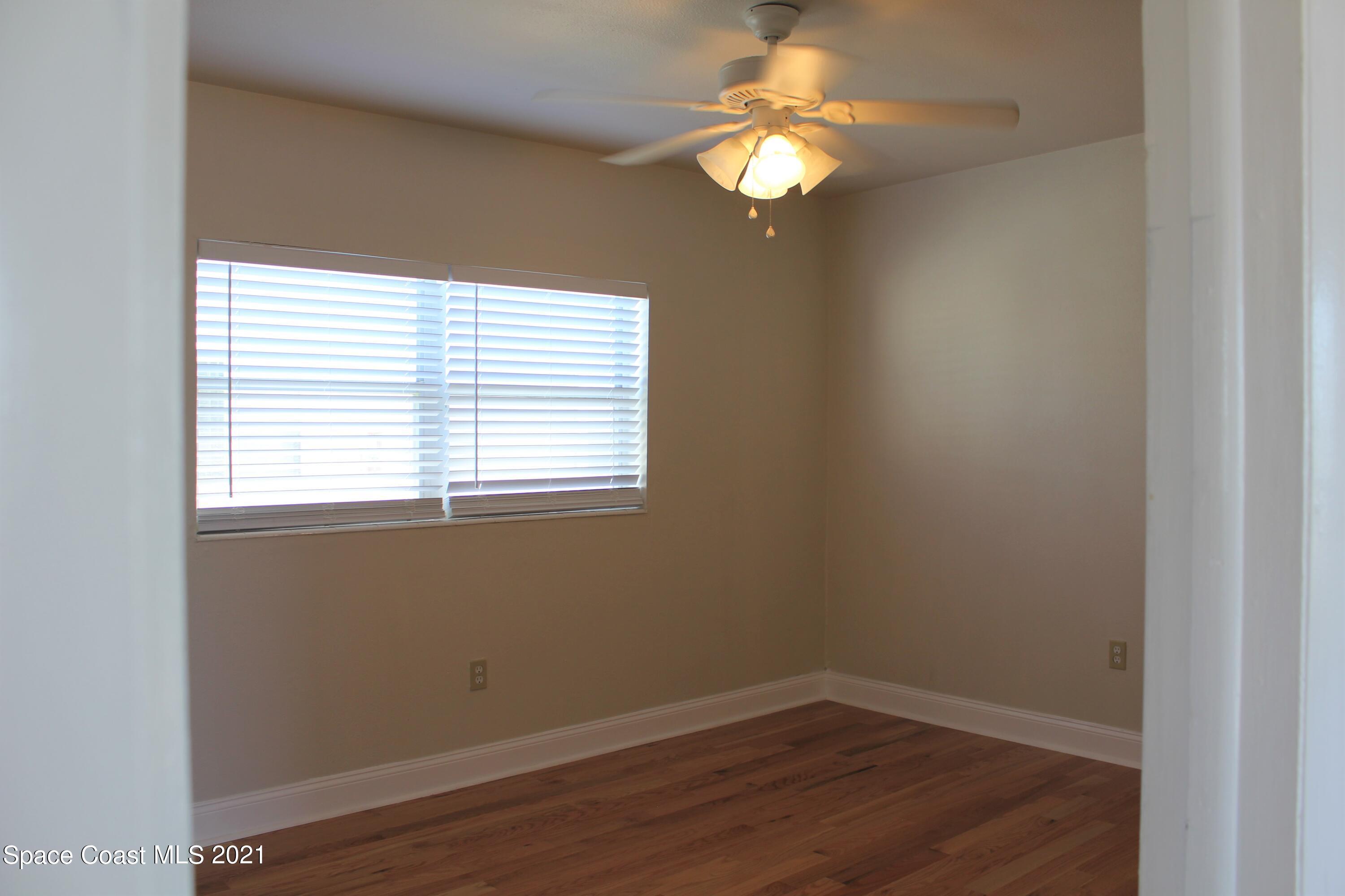 651 Palm Drive, Unit E3 Satellite Beach, FL 32937 - Photo 17 of 25 an empty room with wooden floor and windows