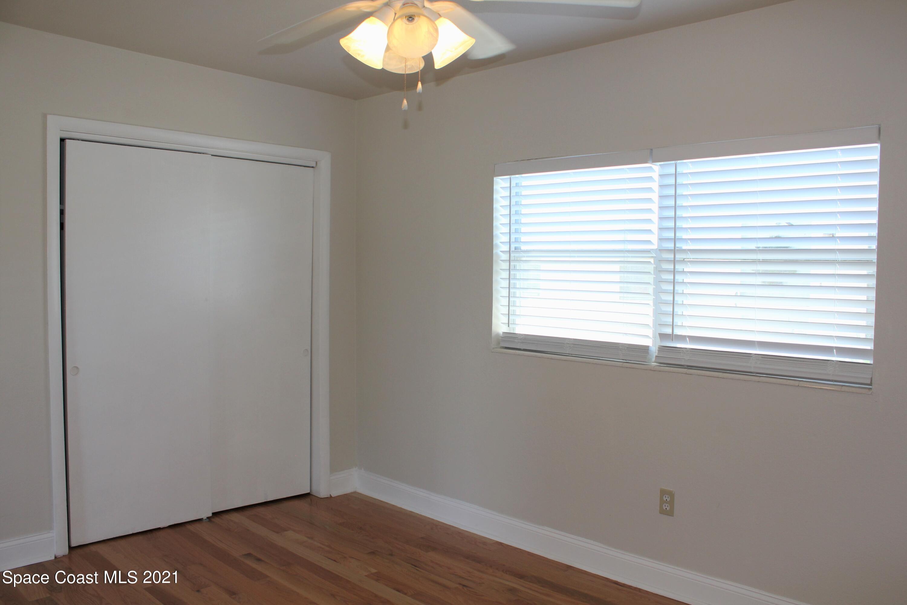651 Palm Drive, Unit E3 Satellite Beach, FL 32937 - Photo 18 of 25 an empty room with wooden floor and windows