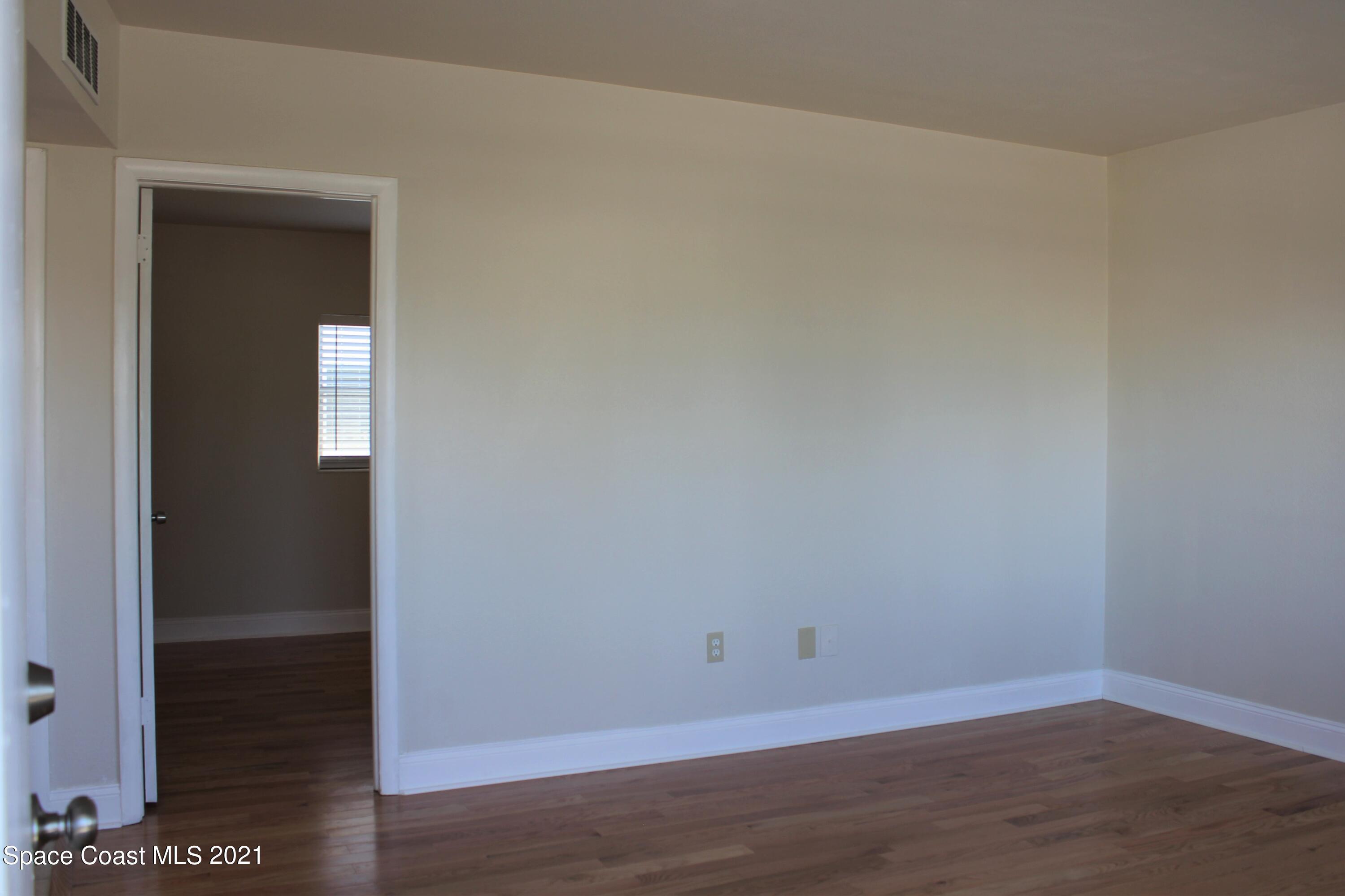 651 Palm Drive, Unit E3 Satellite Beach, FL 32937 - Photo 5 of 25 a view of a small space with wooden floor and a window
