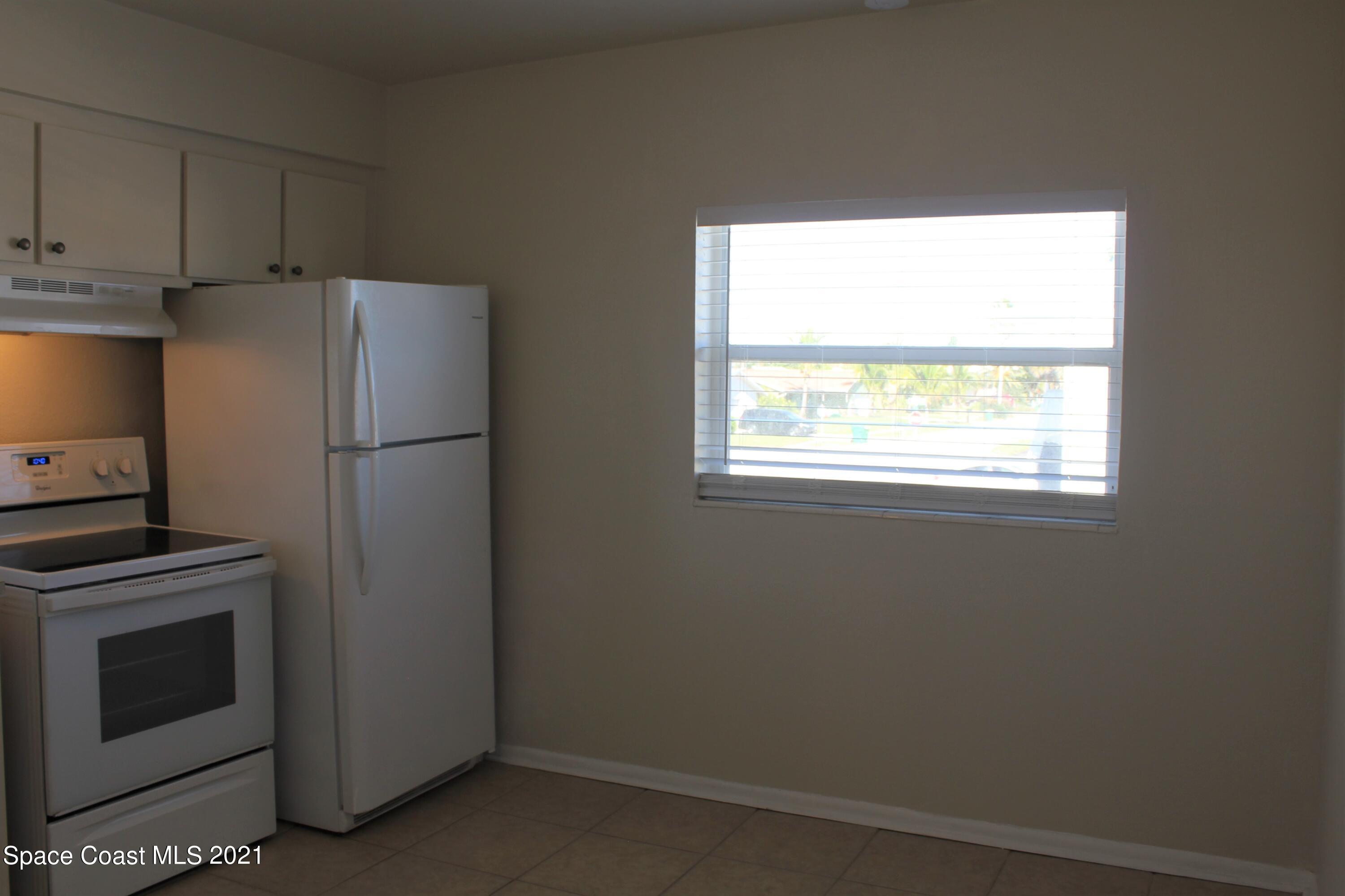 651 Palm Drive, Unit E3 Satellite Beach, FL 32937 - Photo 9 of 25 a kitchen with a refrigerator and window