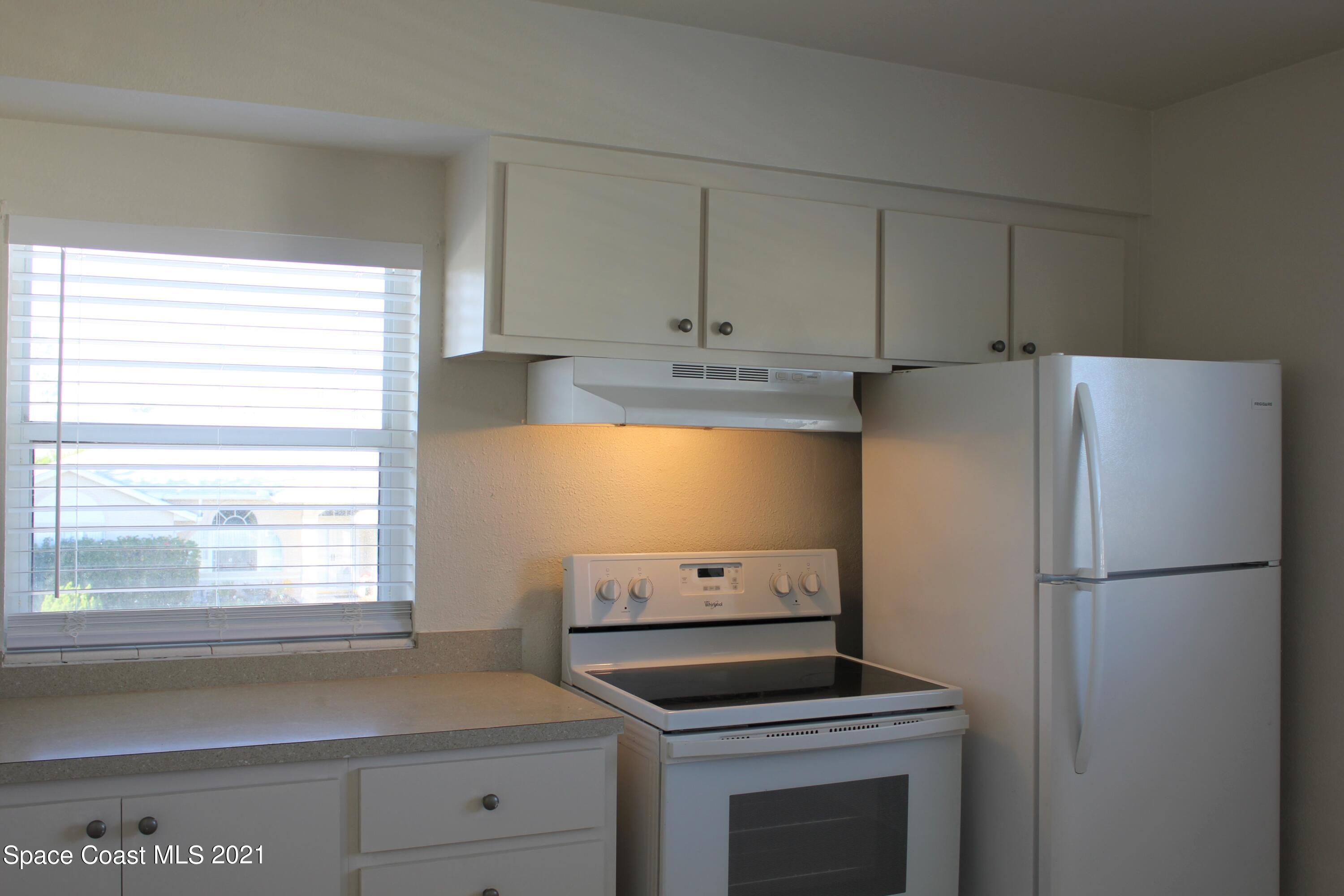 651 Palm Drive, Unit E3 Satellite Beach, FL 32937 - Photo 10 of 25 a kitchen with appliances cabinets and a window