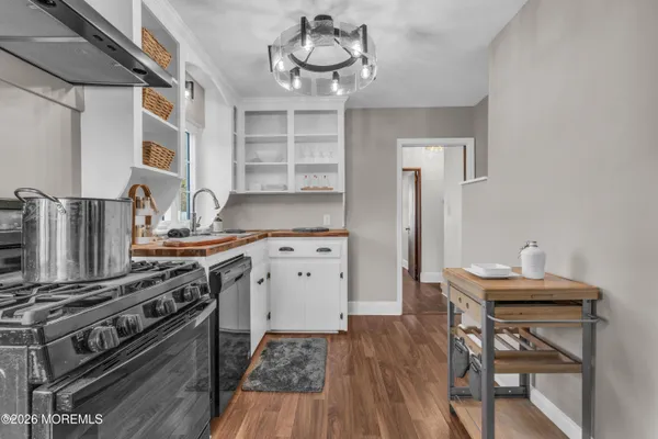 a kitchen with stainless steel appliances a stove a table and chairs in it