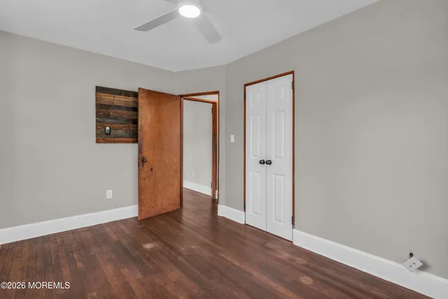 an empty room with wooden floor and closet