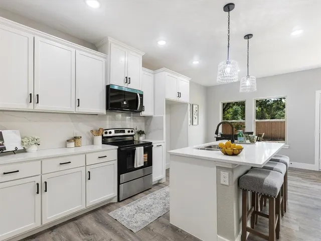 a kitchen with a sink a stove and chairs