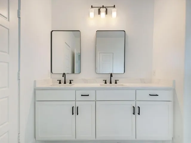 a bathroom with double vanity sinks and a mirror