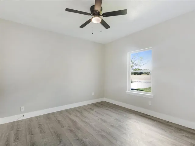 an empty room with a window and a fan