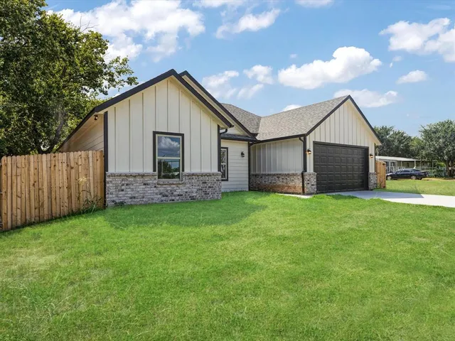 a view of backyard of house with wooden fence