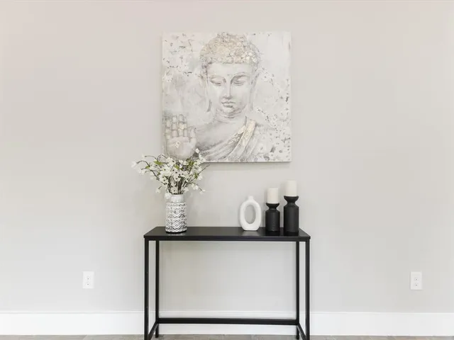 a room with a wall clock and a potted plant