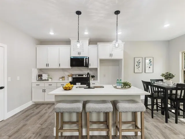 a kitchen with a dining table chairs and cabinets