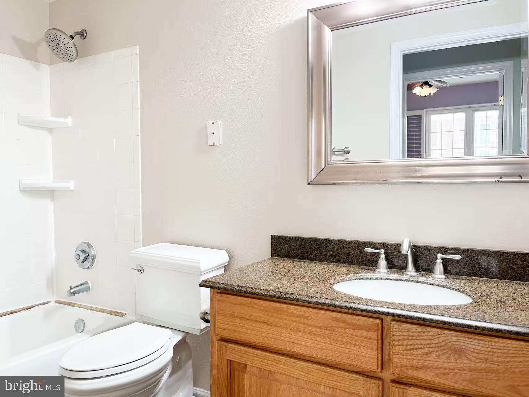1570 Spring Gate Dr., Unit 7109 McLean, VA 22102 - Photo 19 of 21 a bathroom with a granite countertop sink a toilet and mirror