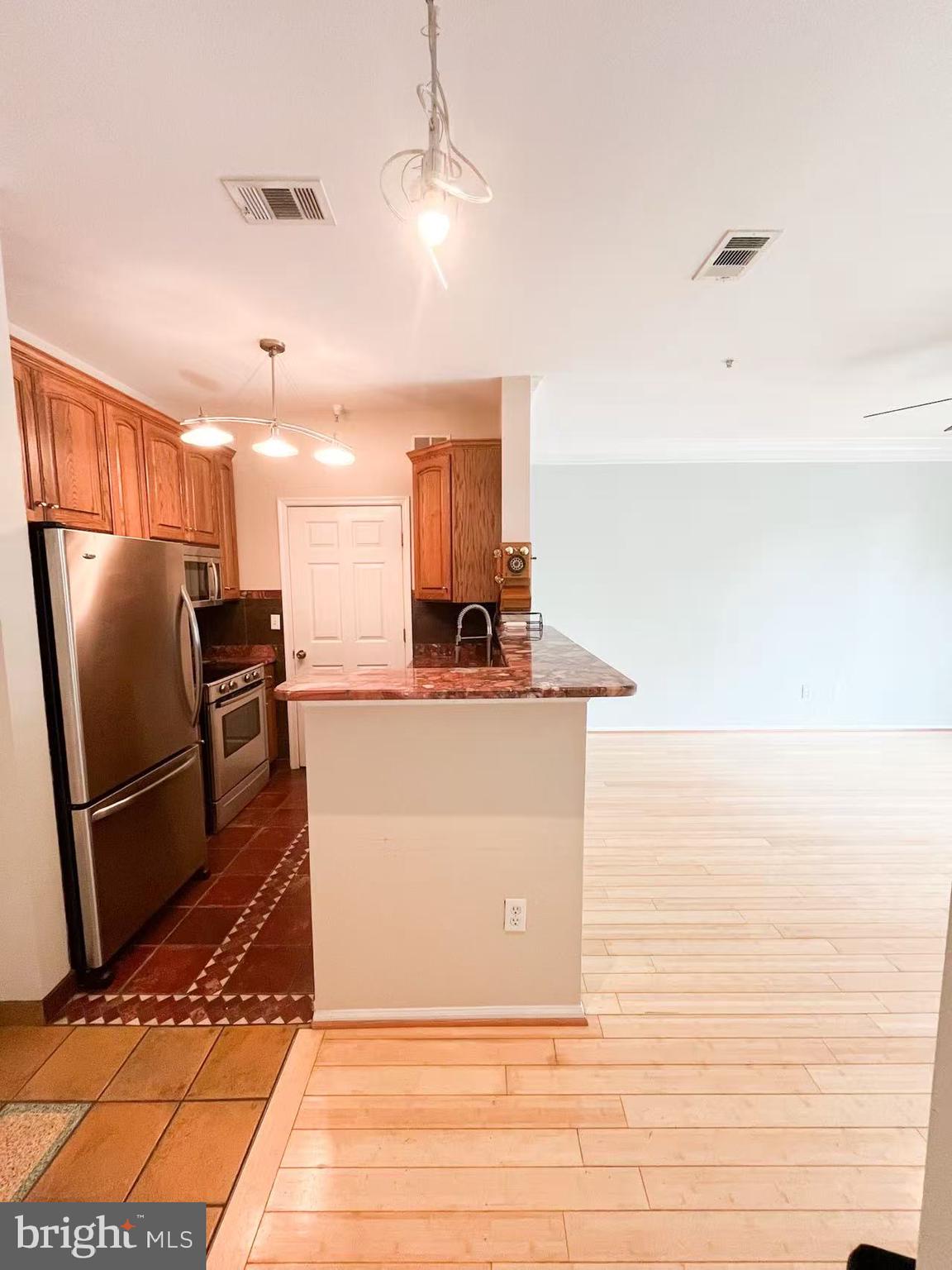 1570 Spring Gate Dr., Unit 7109 McLean, VA 22102 - Photo 3 of 21 a view of kitchen with stainless steel appliances wooden floor and chair