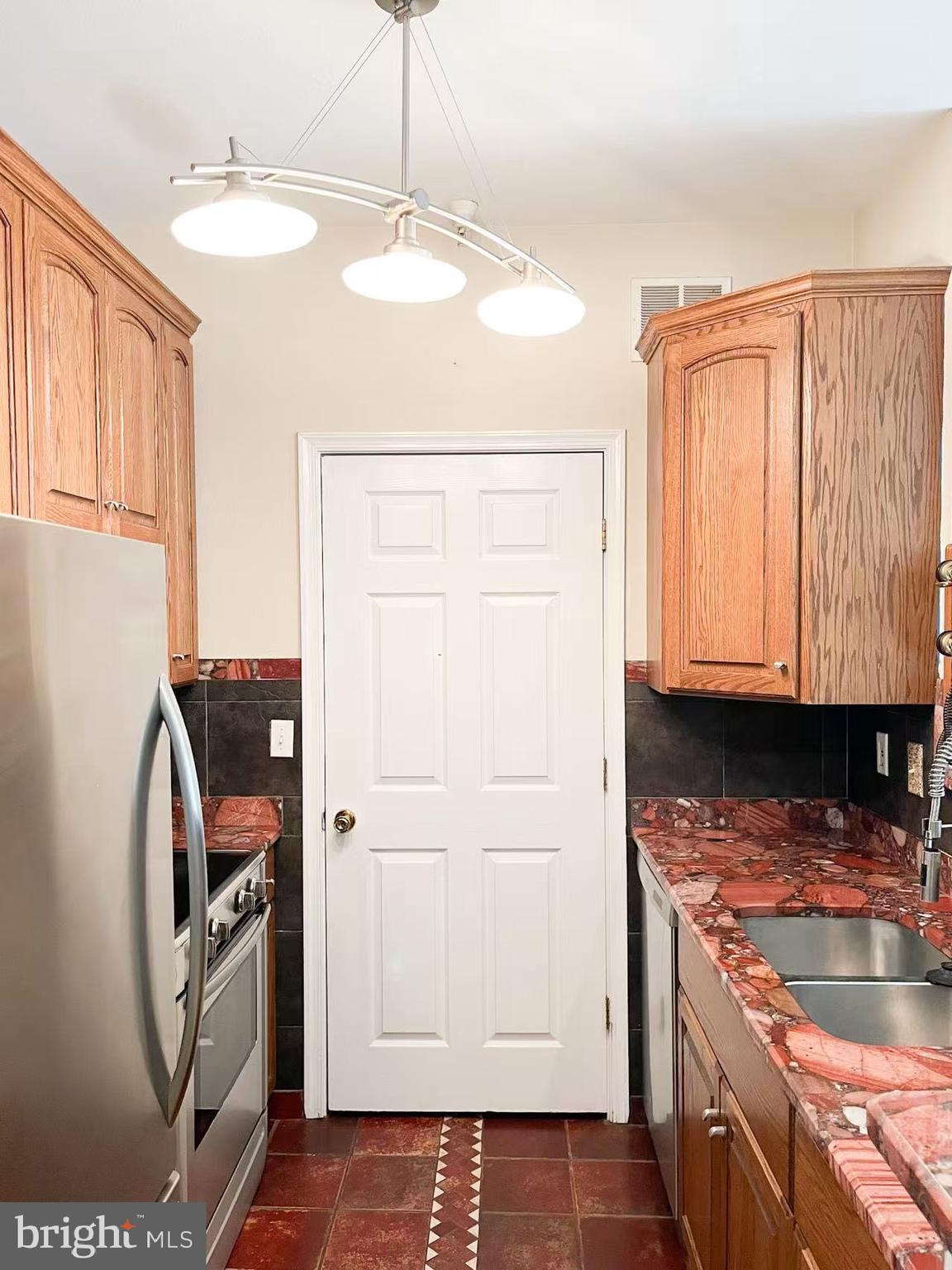 1570 Spring Gate Dr., Unit 7109 McLean, VA 22102 - Photo 4 of 21 a kitchen with a sink a washer and dryer