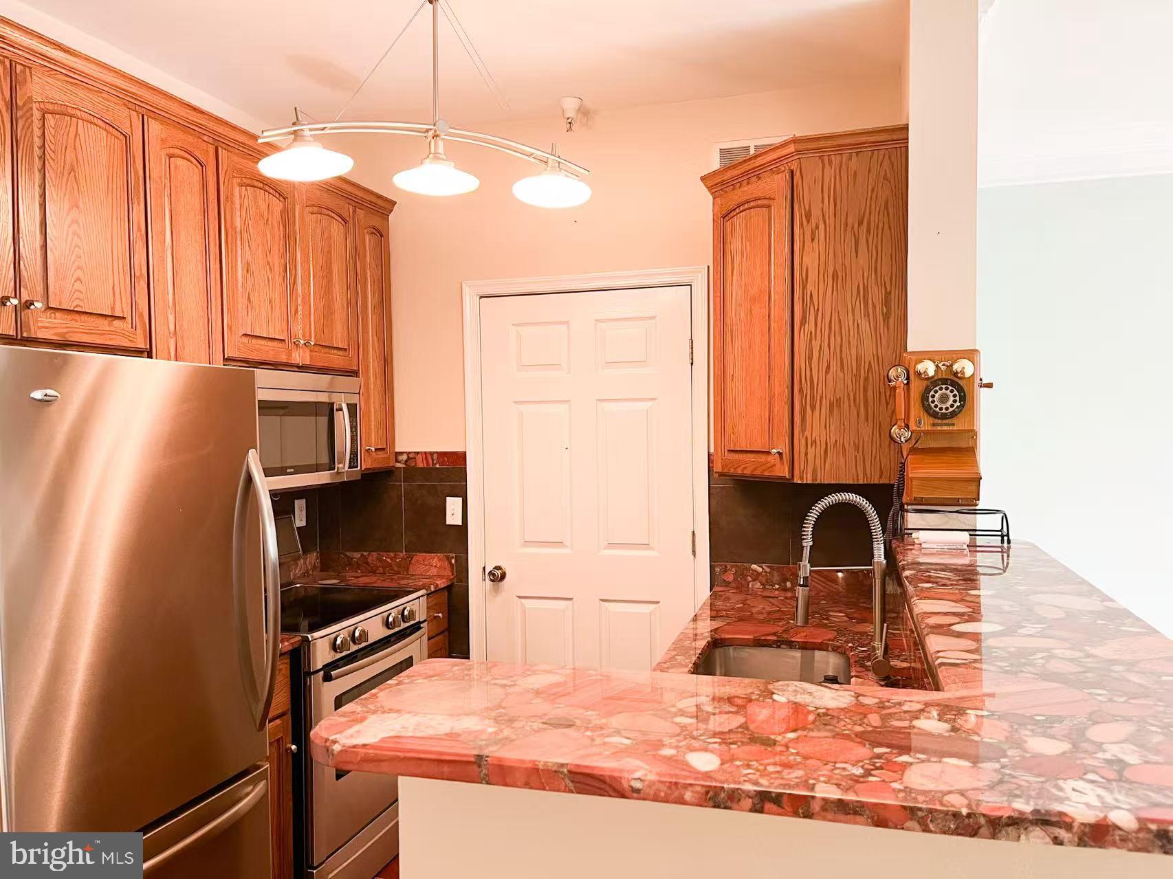 1570 Spring Gate Dr., Unit 7109 McLean, VA 22102 - Photo 7 of 21 a kitchen with a refrigerator stove and sink