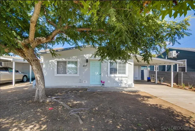 a view of a house with a tree in front of it