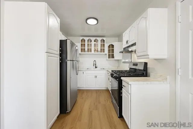 a kitchen with stainless steel appliances granite countertop a refrigerator and a stove
