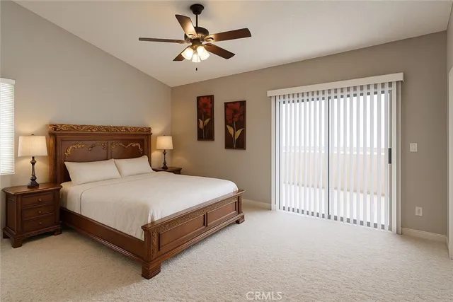 a bedroom with a bed chandelier and a window
