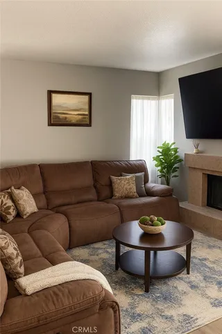 a living room with furniture a flat screen tv and a window