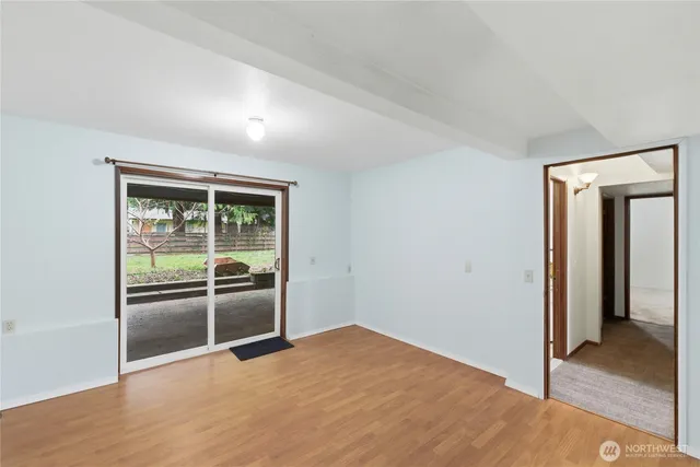 an empty room with wooden floor and natural light